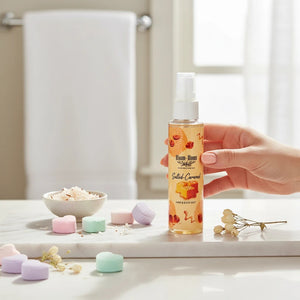 Bloom-Bloom Luxury Bath & Body treats Salted Caramel Hair & Body Mist with Panthenol & Aloe Vera, 100ml bottle held by hand.